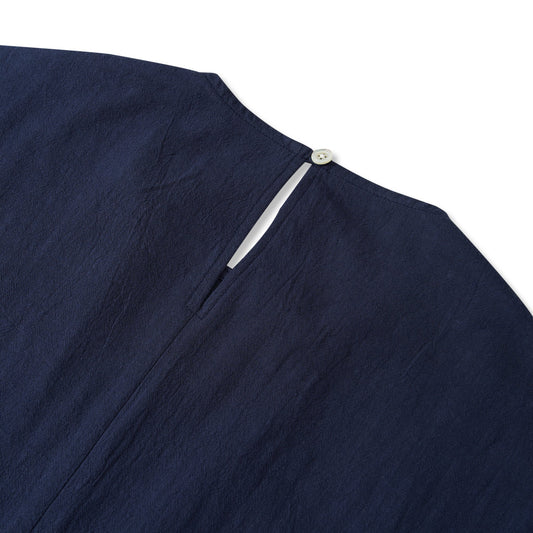 Back view of navy blue women's blouse, button-back design